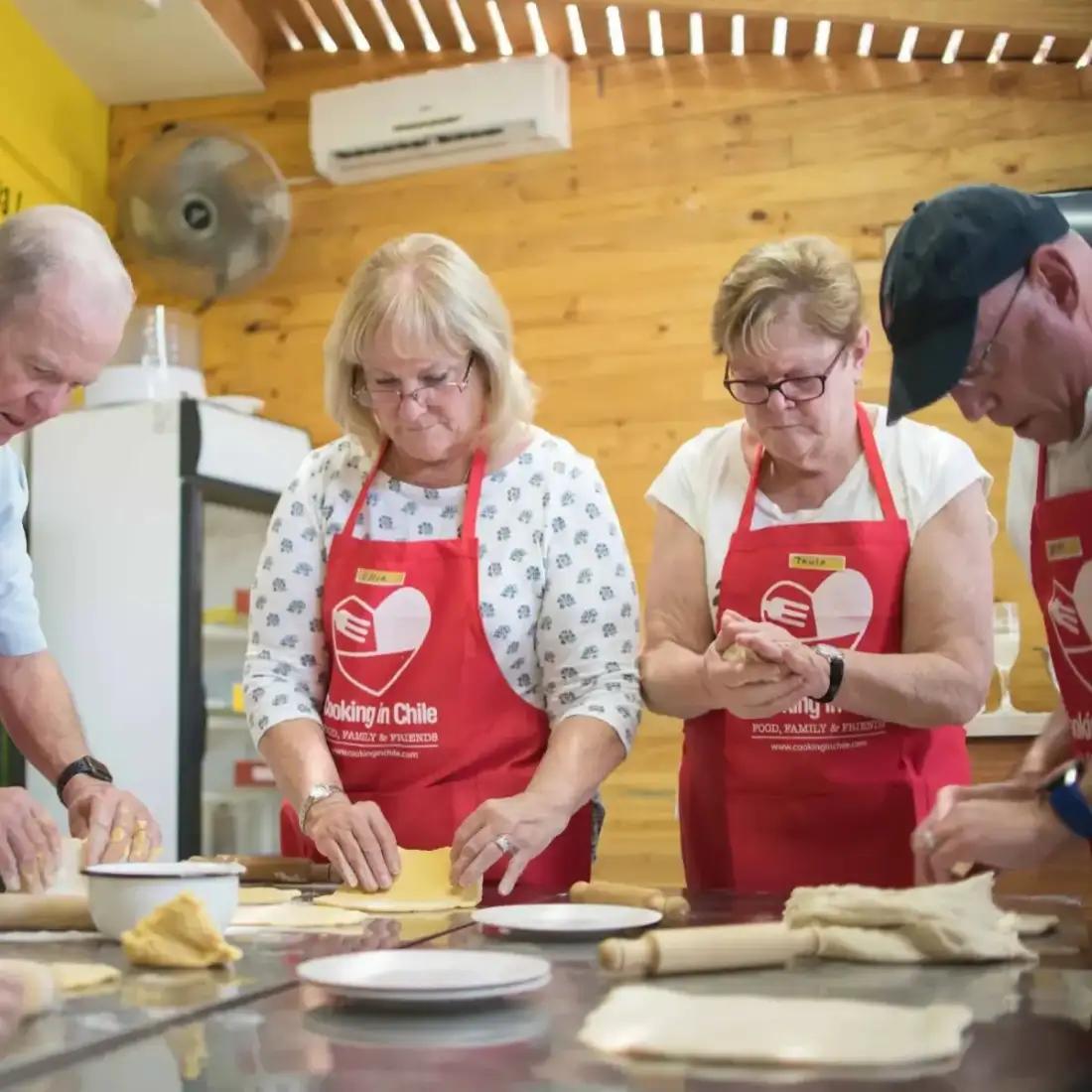 Grupo amasando con delantales de Cooking in Chile