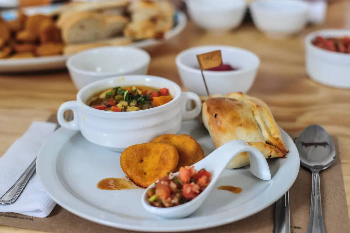 Plato con sopaipillas, pebre y empanada